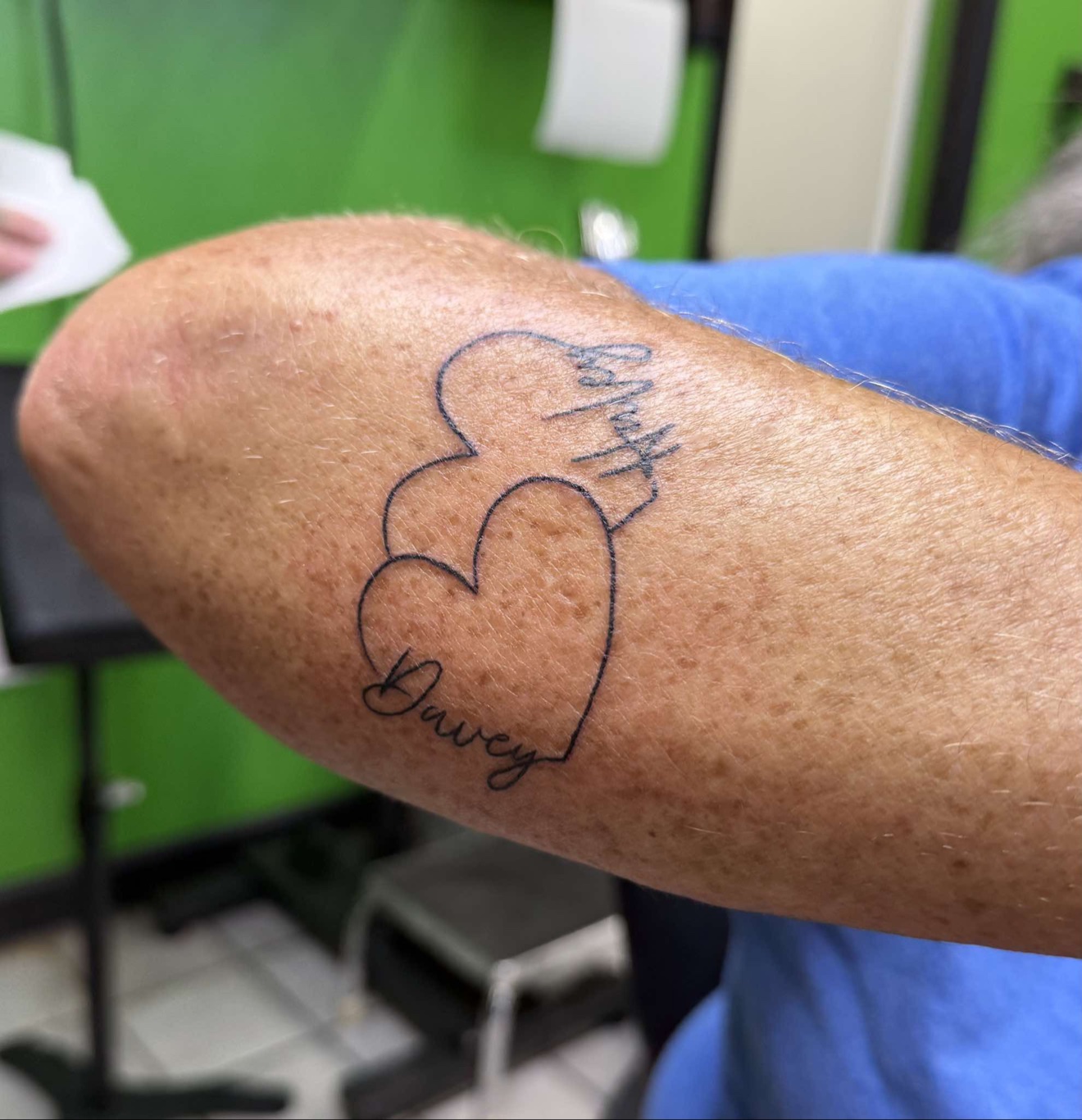 Interlocking hearts with script names tattoo on an arm, Off Grid Tattoo Ellijay